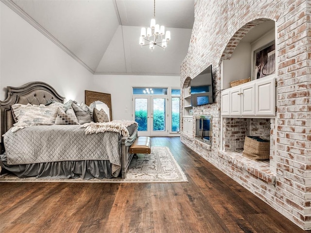 bedroom with dark wood-type flooring, a chandelier, a brick fireplace, access to exterior, and arched walkways