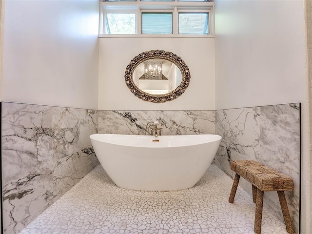 bathroom with tile walls, a wainscoted wall, and a freestanding bath