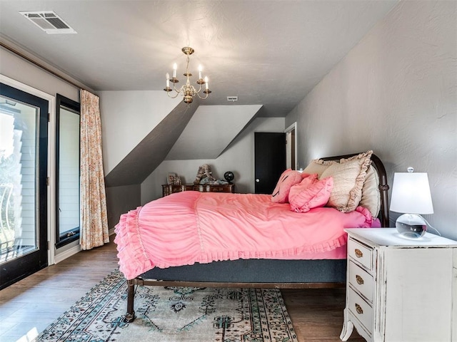 bedroom with wood finished floors and a chandelier