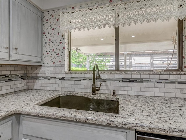8709 NW 86th St, Oklahoma City, OK 73132 - kitchen featuring a sink, tasteful backsplash, light stone countertops, and white cabinetry