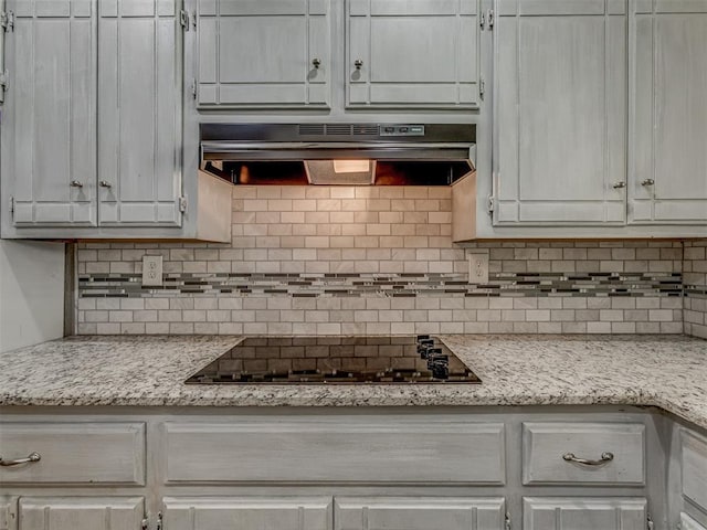 8709 NW 86th St, Oklahoma City, OK 73132 - kitchen with under cabinet range hood, black electric stovetop, and decorative backsplash