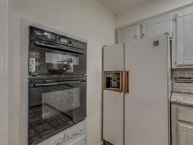 8709 NW 86th St, Oklahoma City, OK 73132 - kitchen featuring white refrigerator with ice dispenser, decorative backsplash, and light stone counters