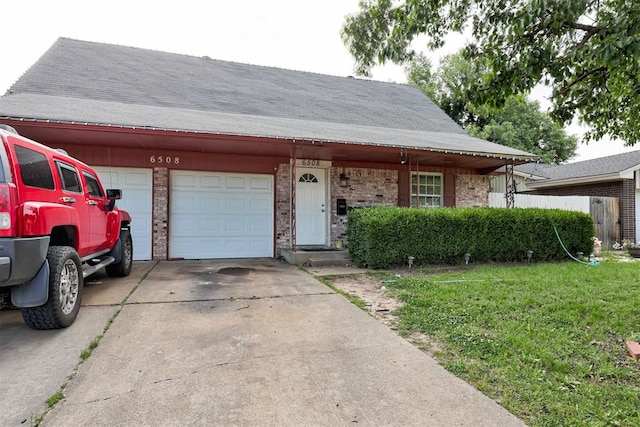 6508 S Harvey Ave, Oklahoma City, OK 73139 - view of front of property featuring an attached garage, driveway, a front yard, brick siding, and a shingled roof