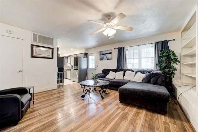 6508 S Harvey Ave, Oklahoma City, OK 73139 - living area featuring light wood finished floors, ceiling fan, a textured ceiling, and baseboards
