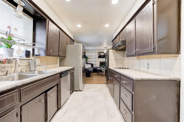 6508 S Harvey Ave, Oklahoma City, OK 73139 - kitchen with dishwasher, a sink, under cabinet range hood, dark brown cabinetry, and recessed lighting