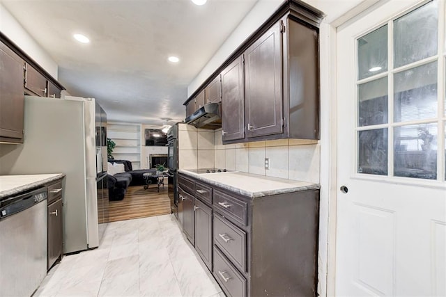 6508 S Harvey Ave, Oklahoma City, OK 73139 - kitchen with stainless steel appliances, dark brown cabinets, under cabinet range hood, light countertops, and light marble finish flooring