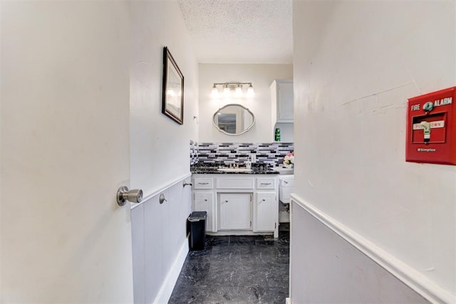 6508 S Harvey Ave, Oklahoma City, OK 73139 - bathroom with vanity, a textured ceiling, and backsplash