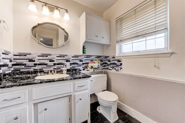 6508 S Harvey Ave, Oklahoma City, OK 73139 - bathroom featuring wainscoting, toilet, vanity, and backsplash