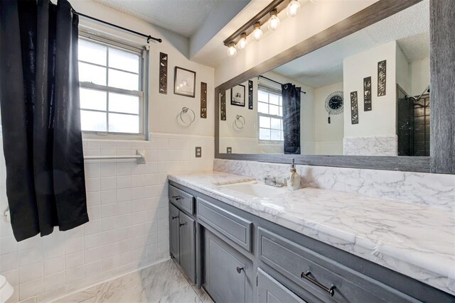 6508 S Harvey Ave, Oklahoma City, OK 73139 - bathroom featuring vanity, wainscoting, and tile walls