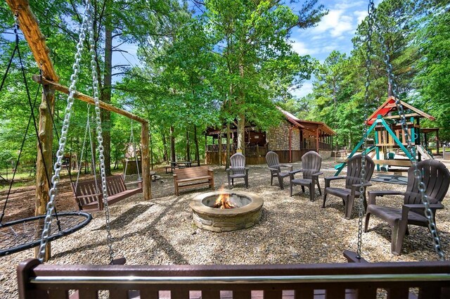 479 Poplar Cir, Broken Bow, OK 74728 - view of patio / terrace featuring a fire pit, a playground, and view of scattered trees