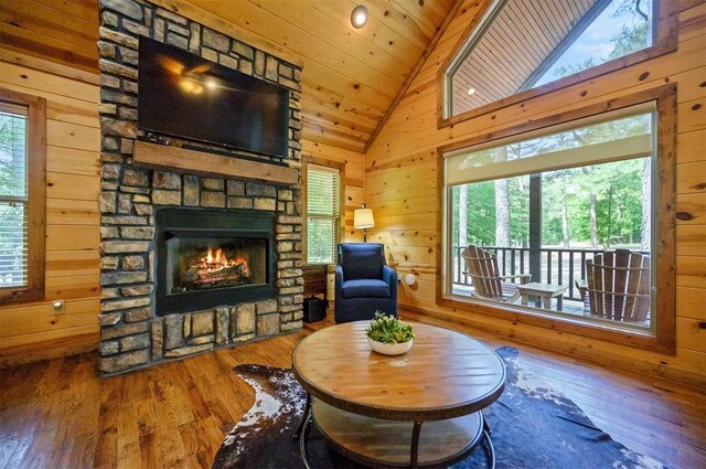 479 Poplar Cir, Broken Bow, OK 74728 - living room featuring vaulted ceiling, wood finished floors, wooden walls, plenty of natural light, and a fireplace