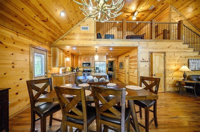 479 Poplar Cir, Broken Bow, OK 74728 - dining space featuring wooden ceiling, wood walls, a chandelier, high vaulted ceiling, and wood finished floors