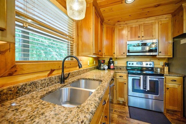 479 Poplar Cir, Broken Bow, OK 74728 - kitchen with stainless steel appliances, a sink, dark wood finished floors, light stone counters, and brown cabinetry