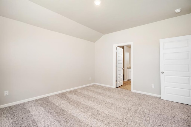 unfurnished bedroom featuring light carpet, baseboards, lofted ceiling, connected bathroom, and recessed lighting