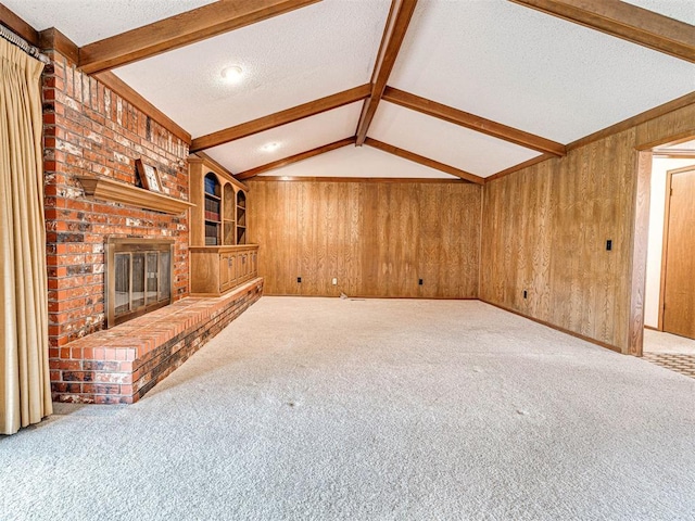 10021 Henderson Dr, Oklahoma City, OK 73139 - unfurnished living room featuring wood walls, carpet floors, a textured ceiling, and a fireplace