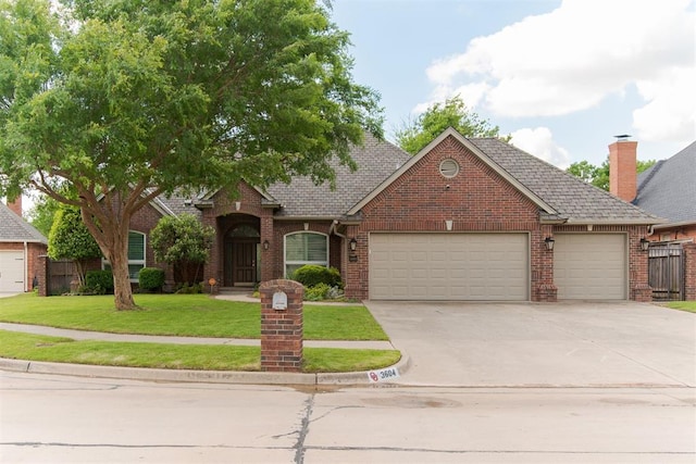 3604 Guilford Ln, Norman, OK 73072 - view of front facade with brick siding, an attached garage, a front yard, concrete driveway, and roof with shingles