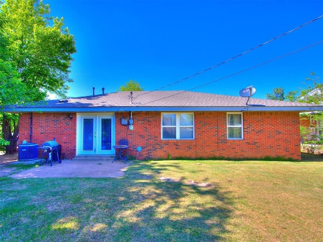 4704 Lisa Ln, Oklahoma City, OK 73115 - back of house with a patio area, brick siding, and a lawn