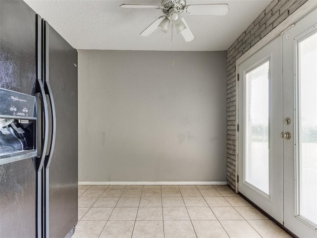 4704 Lisa Ln, Oklahoma City, OK 73115 - kitchen with black fridge with ice dispenser, ceiling fan, and light tile patterned flooring