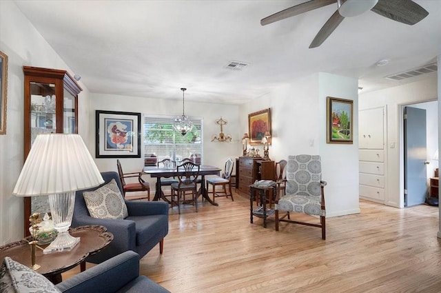 living area with light wood-style flooring, ceiling fan, and baseboards