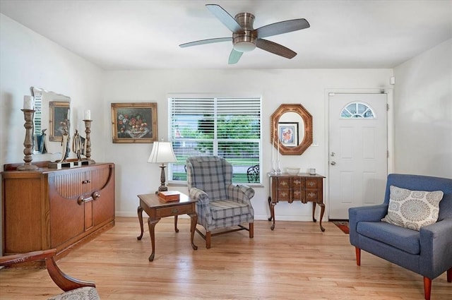 sitting room featuring light wood-type flooring, a ceiling fan, and baseboards