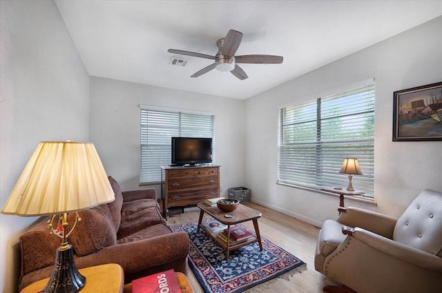 living area with wood finished floors, ceiling fan, and baseboards
