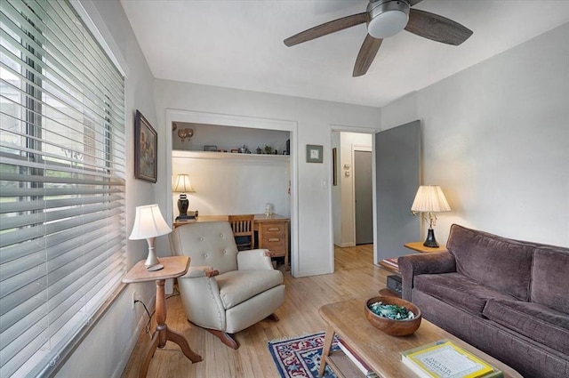 living room featuring light wood-type flooring and a ceiling fan