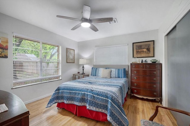 bedroom with wood finished floors, baseboards, a closet, and ceiling fan
