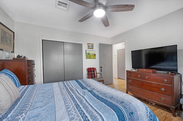 bedroom with wood finished floors, a closet, and a ceiling fan