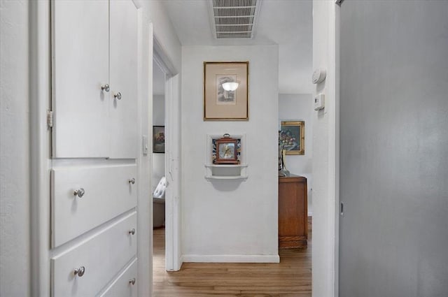 hallway with wood finished floors and baseboards