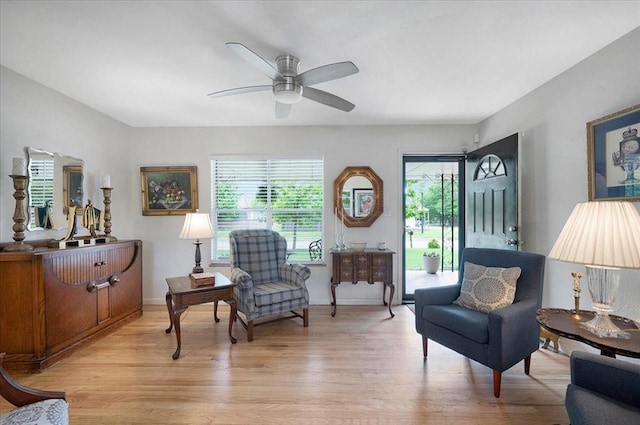 living area featuring light wood-style flooring and a ceiling fan