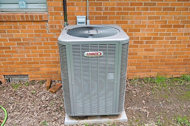 exterior view of central AC unit, brick siding, and crawl space