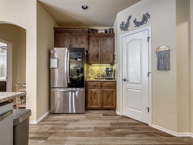 15101 SE 58th St, Choctaw, OK 73020 - kitchen with smart refrigerator, arched walkways, light wood finished floors, and backsplash
