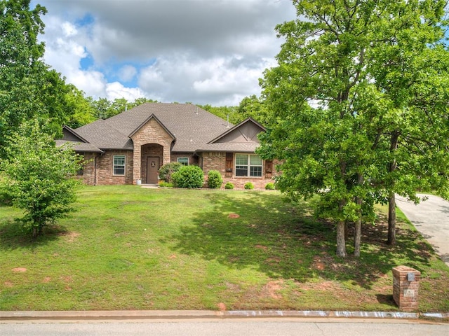 15101 SE 58th St, Choctaw, OK 73020 - view of front of home featuring a front yard, stone siding, a shingled roof, and brick siding