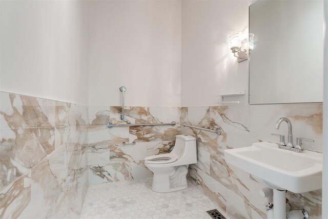 614 NW 8th St Unit 1-4, Oklahoma City, OK 73102 - bathroom featuring tile walls, toilet, and a wainscoted wall