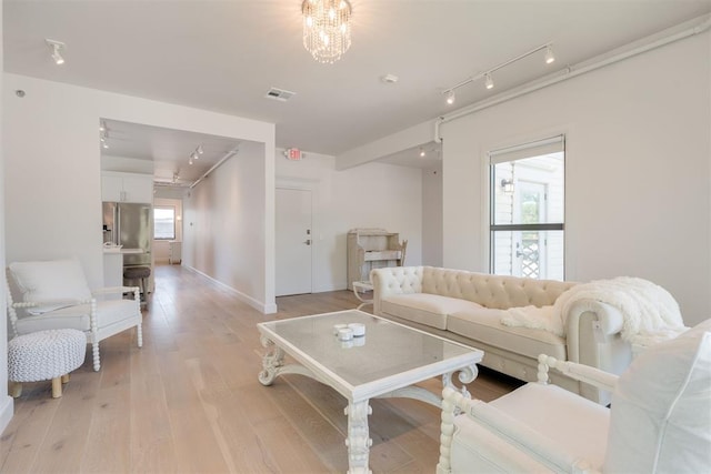 614 NW 8th St Unit 1-4, Oklahoma City, OK 73102 - living room featuring rail lighting, healthy amount of natural light, light wood-style flooring, and baseboards