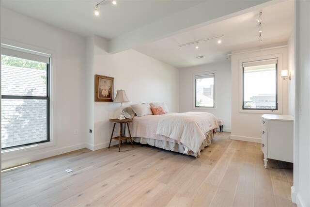 614 NW 8th St Unit 1-4, Oklahoma City, OK 73102 - bedroom with rail lighting, light wood-type flooring, and baseboards