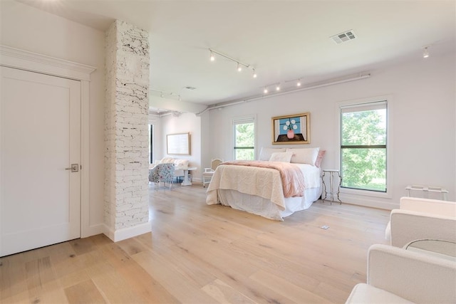 614 NW 8th St Unit 1-4, Oklahoma City, OK 73102 - bedroom with light wood-style floors, rail lighting, multiple windows, and baseboards