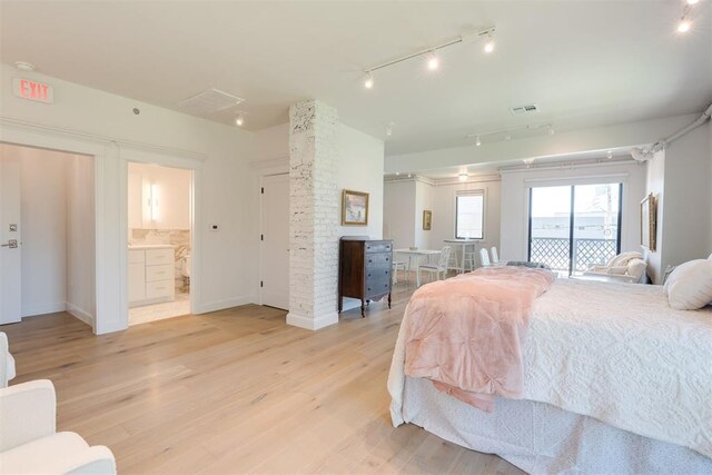 614 NW 8th St Unit 1-4, Oklahoma City, OK 73102 - bedroom featuring track lighting, access to exterior, light wood-type flooring, baseboards, and connected bathroom