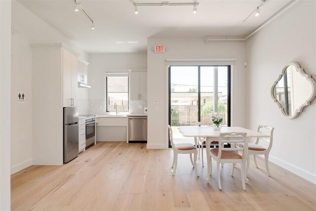 614 NW 8th St Unit 1-4, Oklahoma City, OK 73102 - dining space featuring track lighting, light wood-style floors, and baseboards