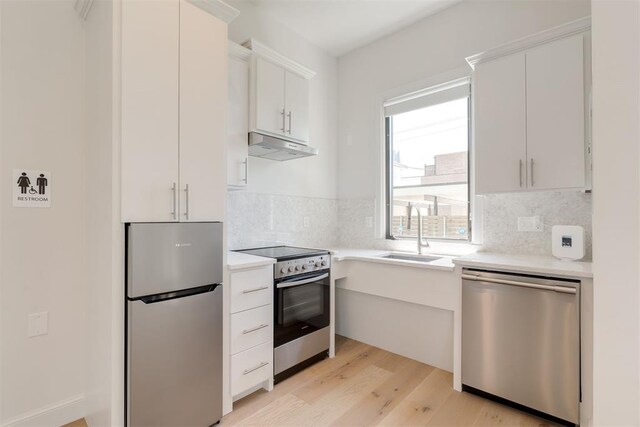 614 NW 8th St Unit 1-4, Oklahoma City, OK 73102 - kitchen with stainless steel appliances, a sink, under cabinet range hood, and light countertops