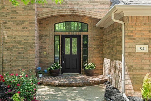 view of exterior entry featuring brick siding
