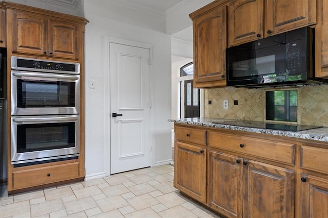 kitchen featuring black appliances, light stone countertops, crown molding, tasteful backsplash, and baseboards