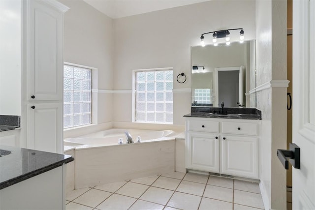 bathroom with vanity, a bath, and tile patterned flooring
