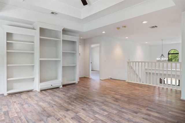 spare room featuring wood finished floors, a chandelier, recessed lighting, ornamental molding, and ceiling fan