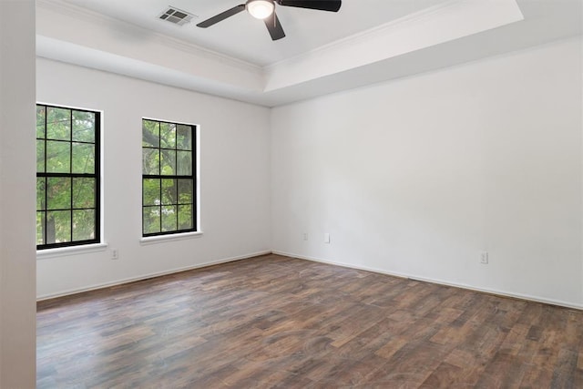 unfurnished room featuring ornamental molding, healthy amount of natural light, wood finished floors, a tray ceiling, and ceiling fan