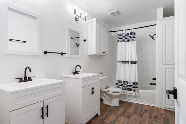 full bath with two vanities, shower / tub combo with curtain, wood finished floors, and toilet