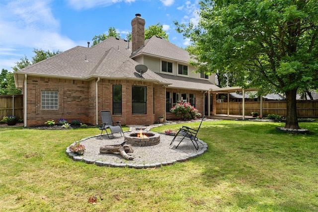 back of property with an outdoor fire pit, a patio area, brick siding, a shingled roof, and a chimney