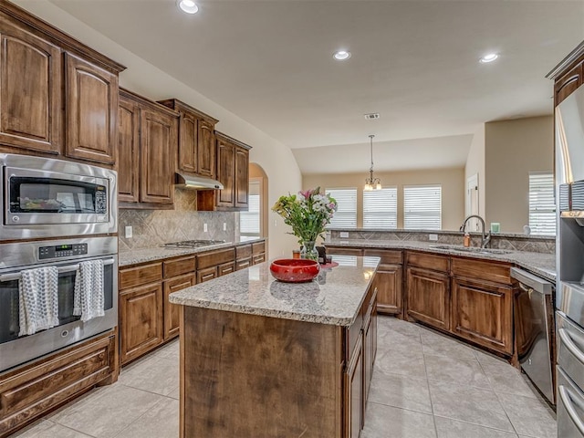 kitchen featuring appliances with stainless steel finishes, a sink, tasteful backsplash, light stone countertops, and light tile patterned floors