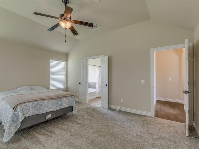 carpeted bedroom featuring lofted ceiling, baseboards, ceiling fan, and ensuite bathroom