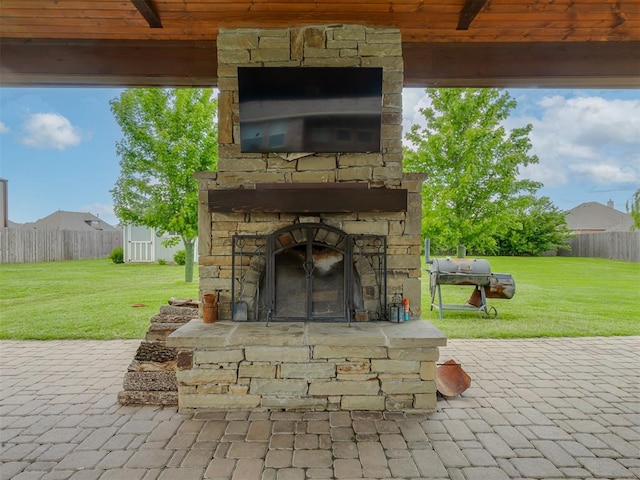 view of patio / terrace featuring an outdoor stone fireplace and grilling area